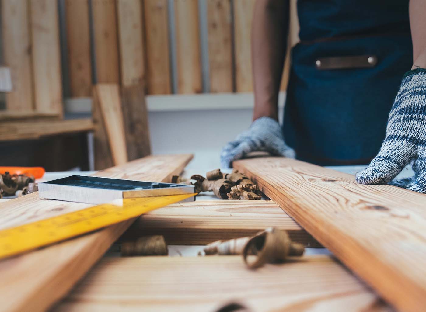 Pieces of wood, ruler and wood shavings with person's hands