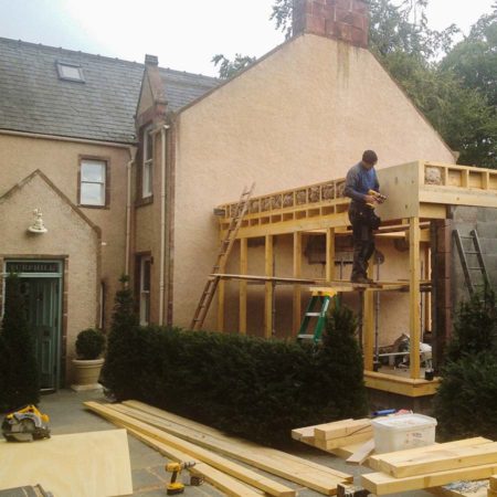 House with part built extension being erected