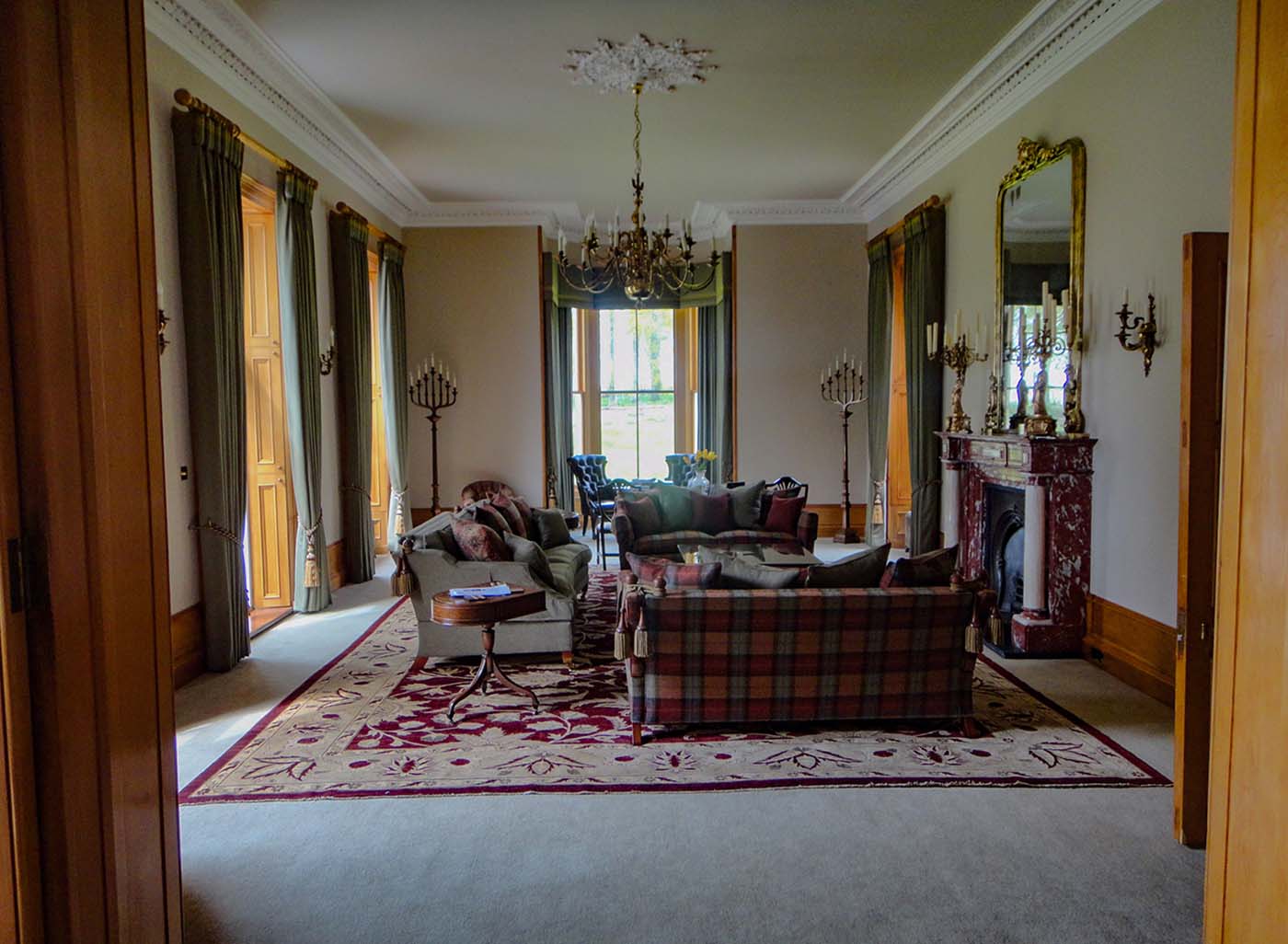 Lounge interiro showing large windows, fireplace, sofa, chairs and rug