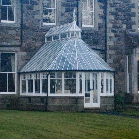 Conservatory with white panelling and glass windows and roof