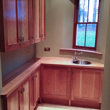 Galley kitchen showing wooden kitchen units and window