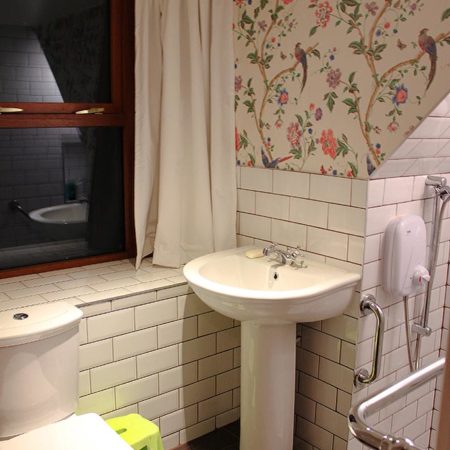 Tradiitonal white tiles in bathroom with toilet and sink in view