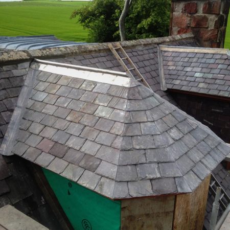 Grey slate roof on an upper building window