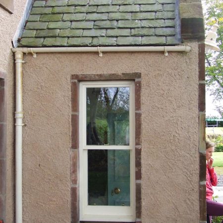 White surround window on side of a small porch