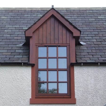 Exterior of window with dark wood surround and small panel panes