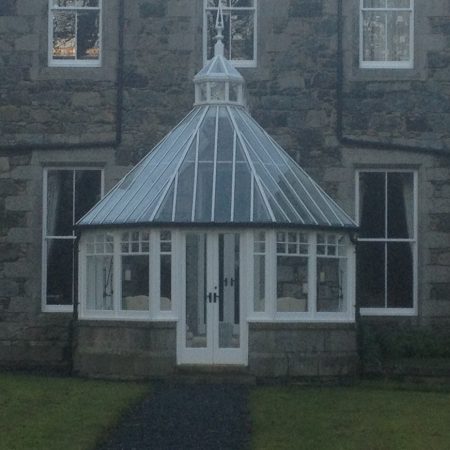 Conservatory with white panelling and glass windows and roof