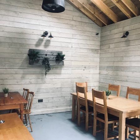 Inside of the Barn at the Market Arms showing wood panelled walls and dining tables and chairs