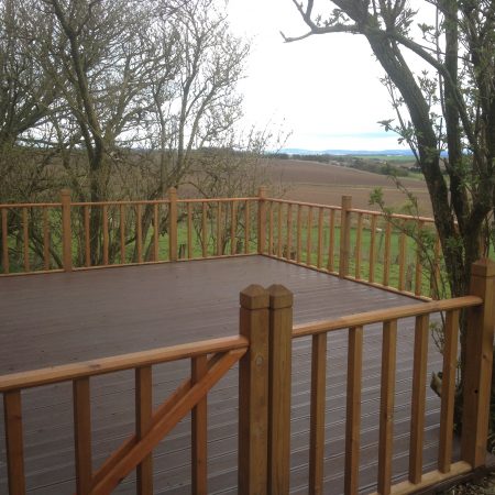 Wooden decked area with handmade wooden staircase rail and handrails