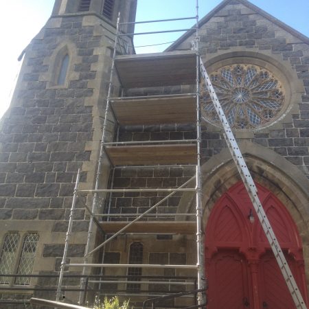 Scaffolding in from of red wooden door at entrance to Portsoy Parish Church